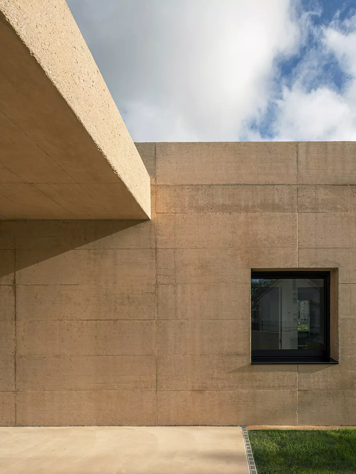 Vivienda unifamiliar contemporánea en hormigón visto con ventana enmarcada, diseñado por SEA arquitectos.
