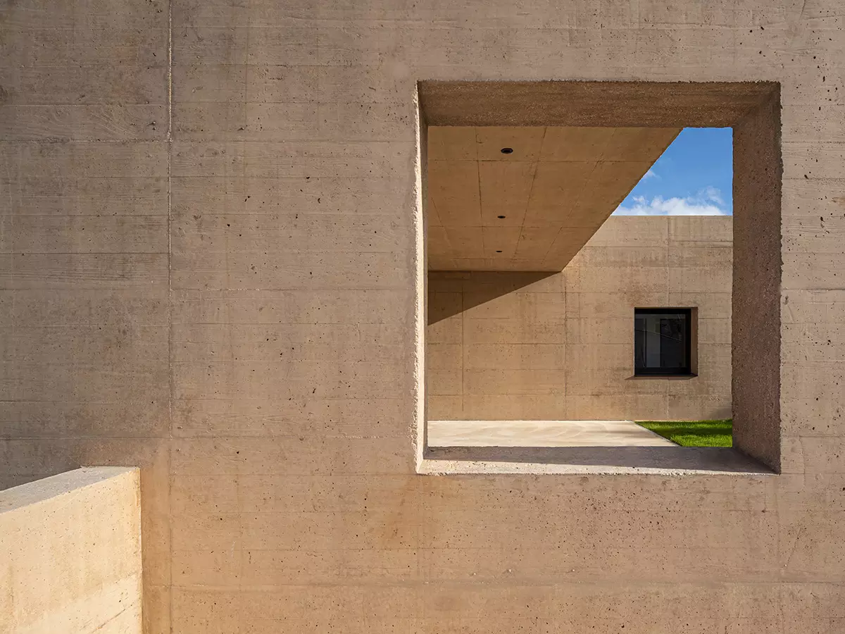 Detalle de patio protegido y muros de hormigón visto en vivienda contemporánea, por estudio de arquitectura SEA.